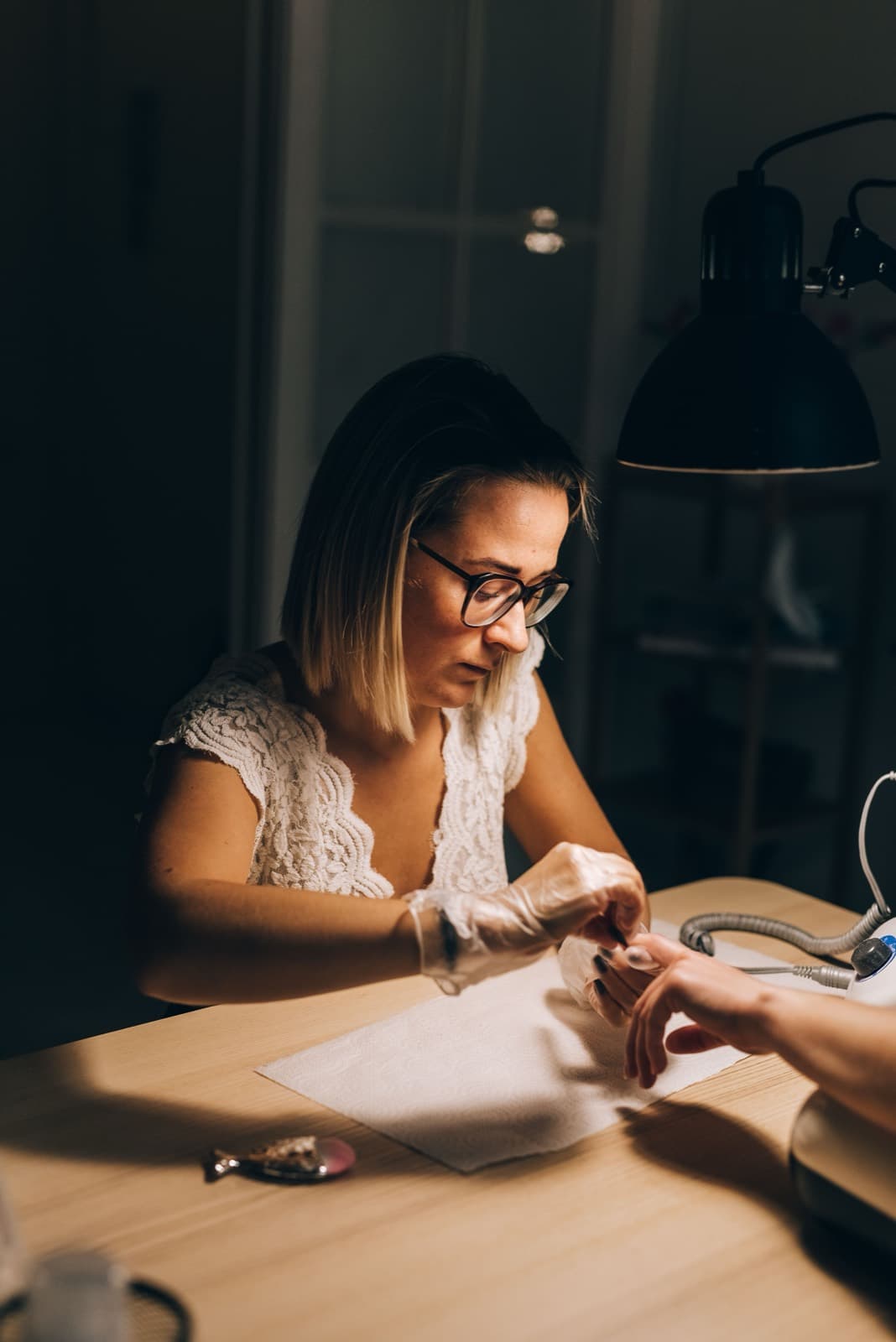 Une professionnelle de l'onglerie au travail sur la main d'une cliente
